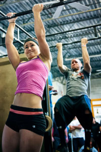 alternate grip pull up demonstrated by female crossfit athlete