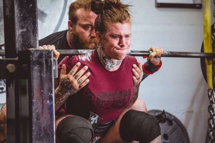 woman at the bottom of a squat on a beginner powerlifting program