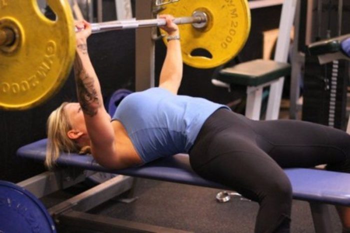 Woman at the top of a bench press