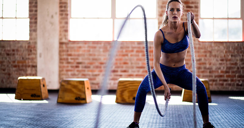 woman exercising with battle ropes as part of Tabata circuit