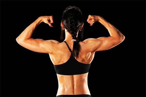 a female tensing her biceps during a workout 