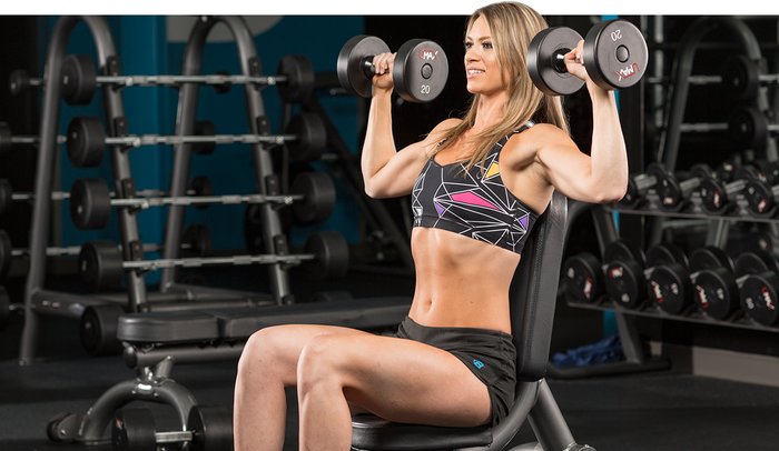 woman performing a seated dumbbell press