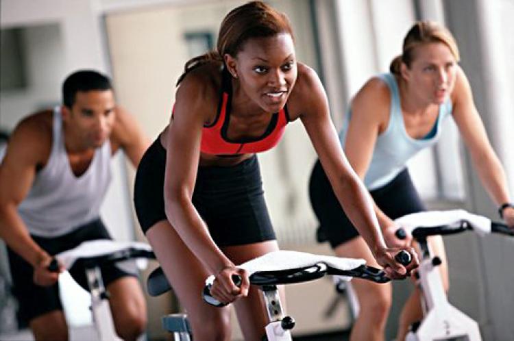 Group of women exercising on a bike in the gym