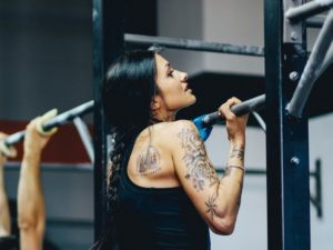 female athlete performing strict pull up