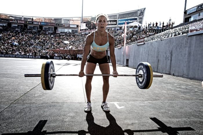 Woman in a competition halfway through a deadlift