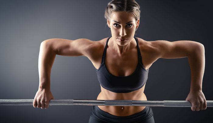 toned woman lifting a bar bell up