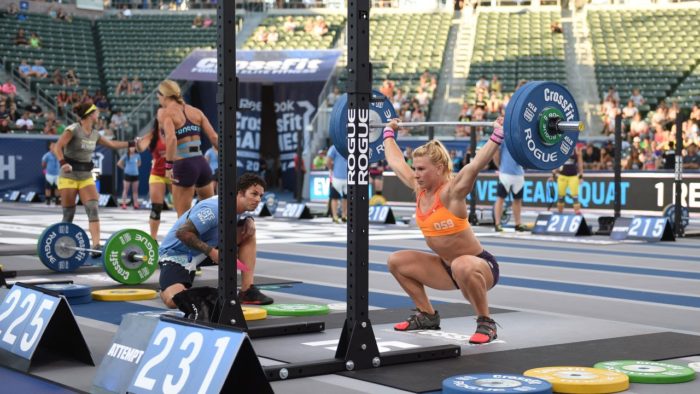 Woman competing in a crossfit competition, at the bottom of an overhead squat